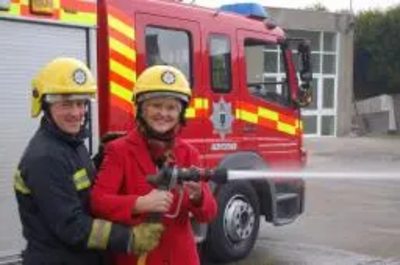 Terrye Teverson with a Falmouth Fireman outsude Falmouth Fire Station